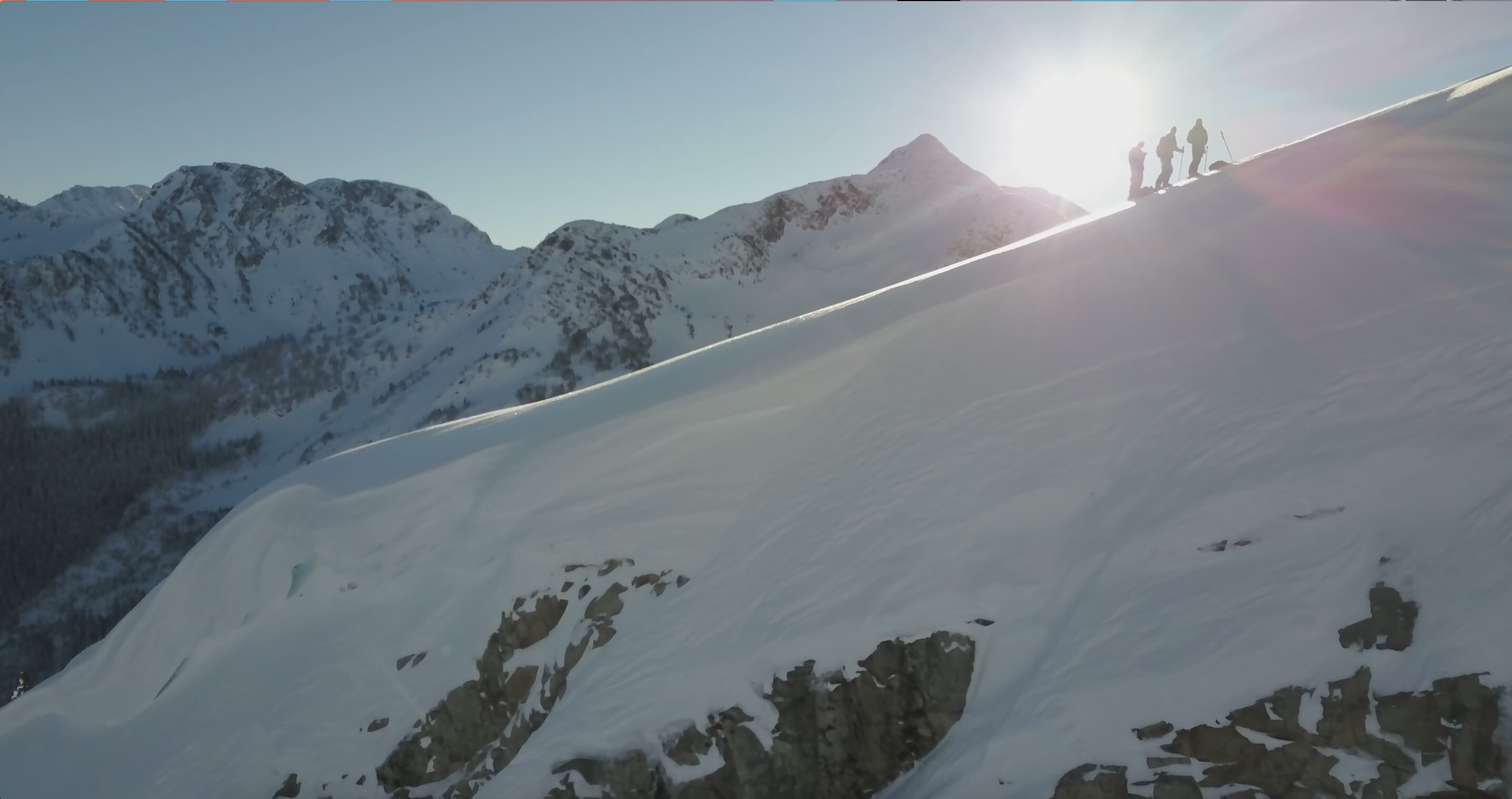 Kieran Nikula and Skiers Hiking Ridge at sunset